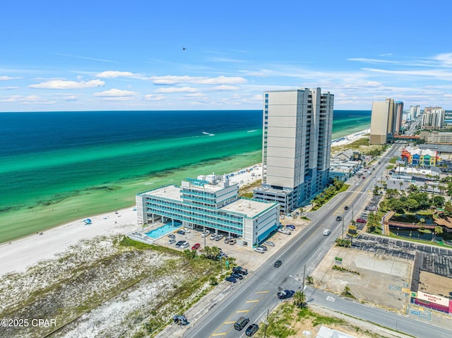 drone / aerial view featuring a city view, a water view, and a beach view