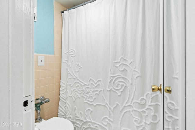 full bath with a shower with shower curtain and tile walls