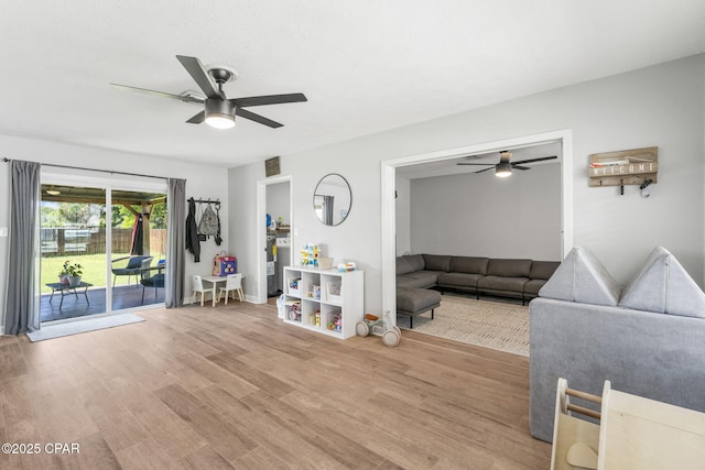 unfurnished living room featuring visible vents, wood finished floors, and a ceiling fan