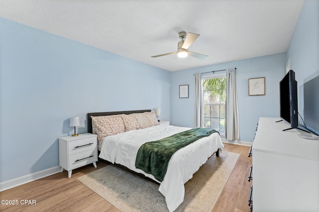 bedroom with a ceiling fan, baseboards, and light wood finished floors