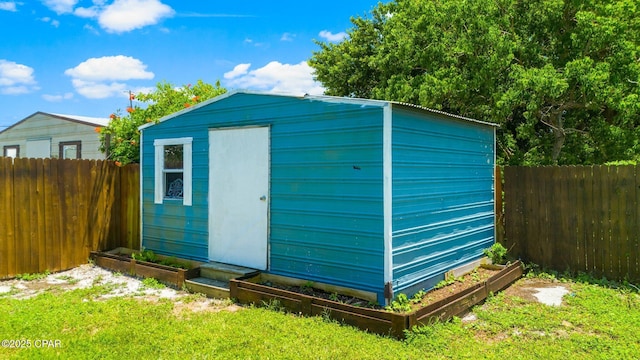 view of shed featuring a fenced backyard and a garden