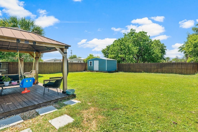 view of yard featuring a fenced backyard, a gazebo, a storage unit, a deck, and an outdoor structure