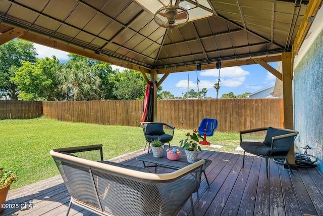 deck featuring a fenced backyard, ceiling fan, a lawn, and a gazebo