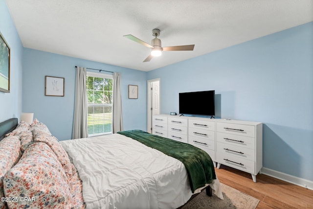 bedroom with light wood finished floors, ceiling fan, and baseboards