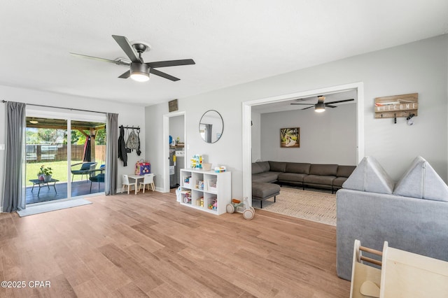 living area with ceiling fan, visible vents, and wood finished floors