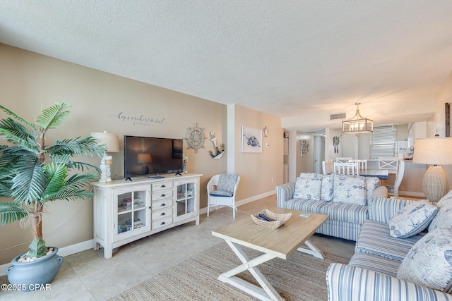 living area with light tile patterned floors, baseboards, visible vents, and a textured ceiling