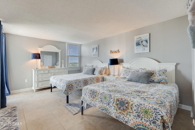 bedroom with light tile patterned floors, baseboards, and a textured ceiling