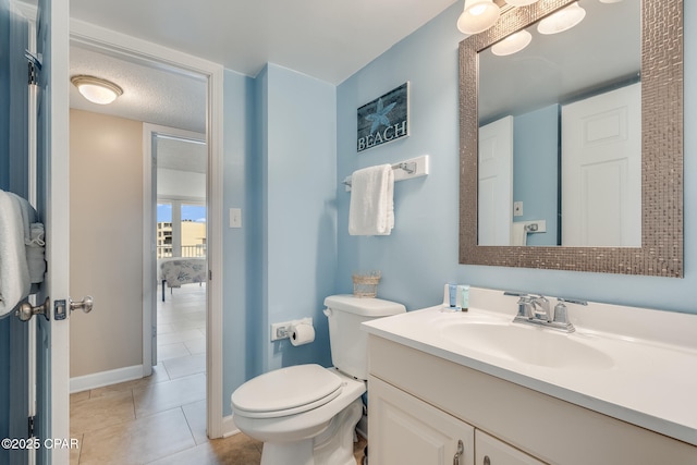 bathroom with vanity, baseboards, tile patterned flooring, a textured ceiling, and toilet