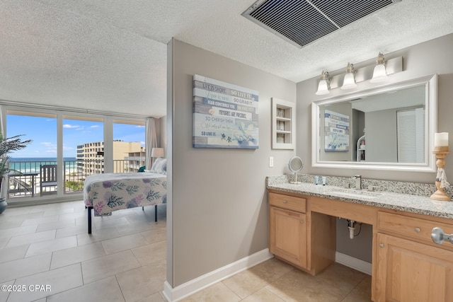 bathroom featuring visible vents, a textured ceiling, tile patterned flooring, baseboards, and vanity