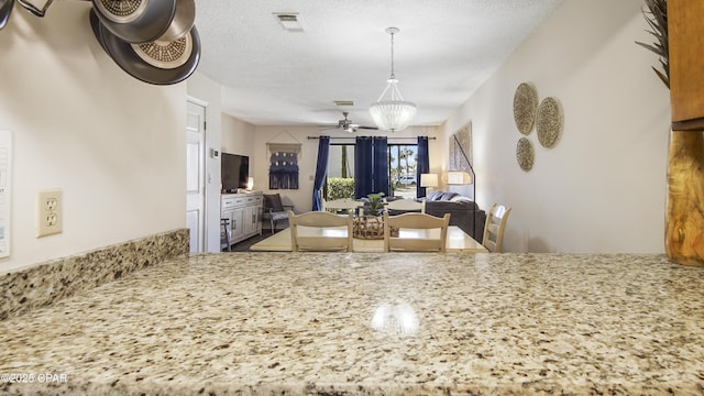 dining area featuring visible vents, a textured ceiling, and an inviting chandelier