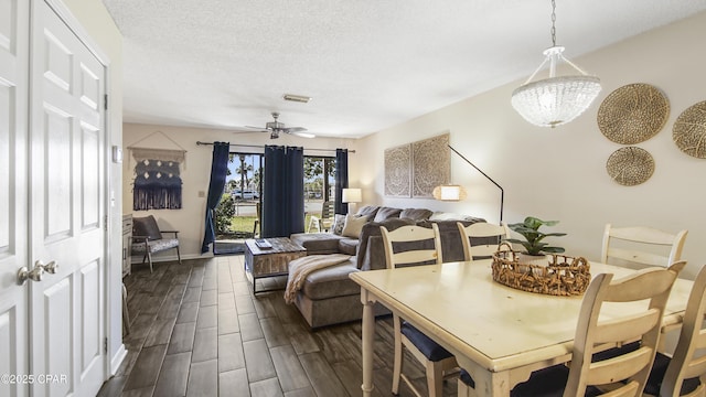 dining space featuring wood finish floors, visible vents, a textured ceiling, and ceiling fan