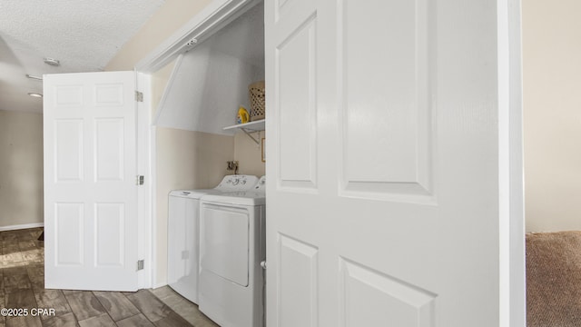 washroom with washer and dryer, a textured ceiling, wood finished floors, and laundry area