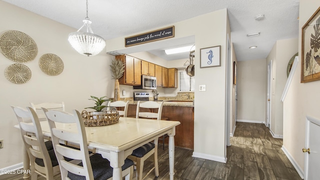 dining room with a textured ceiling, dark wood-type flooring, and baseboards