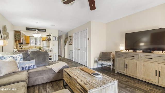 living room featuring baseboards, dark wood-type flooring, and a ceiling fan