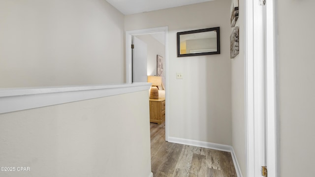 hallway featuring baseboards and light wood finished floors