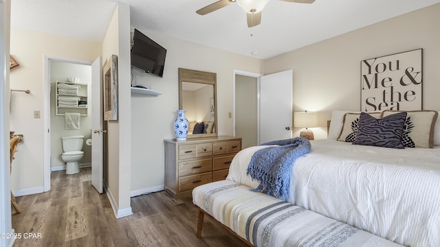 bedroom featuring ceiling fan, connected bathroom, baseboards, and wood finished floors