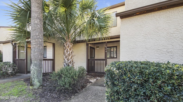 entrance to property with stucco siding and covered porch