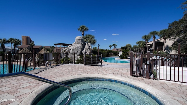 pool featuring a patio area, a hot tub, and fence