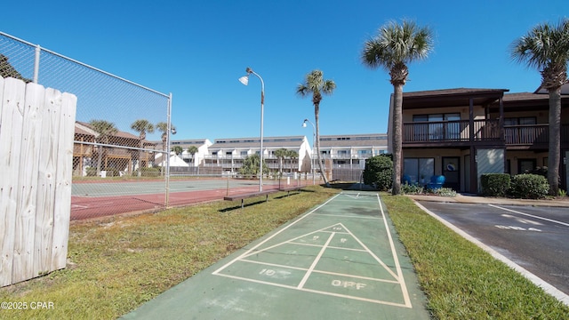 view of community with shuffleboard and fence