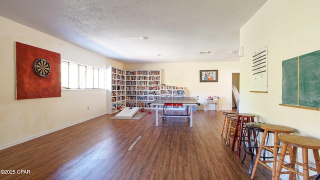 interior space featuring baseboards, wood finished floors, visible vents, and a textured ceiling