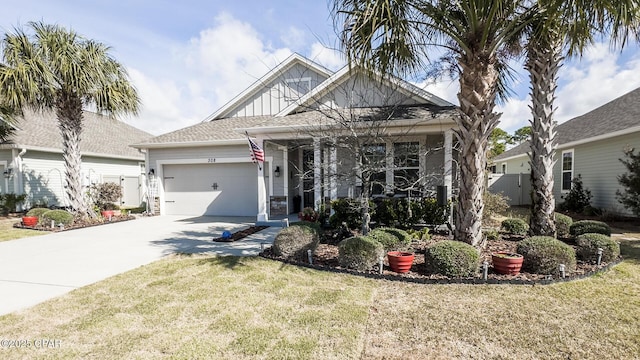 view of front of house with a front lawn, driveway, fence, board and batten siding, and a garage