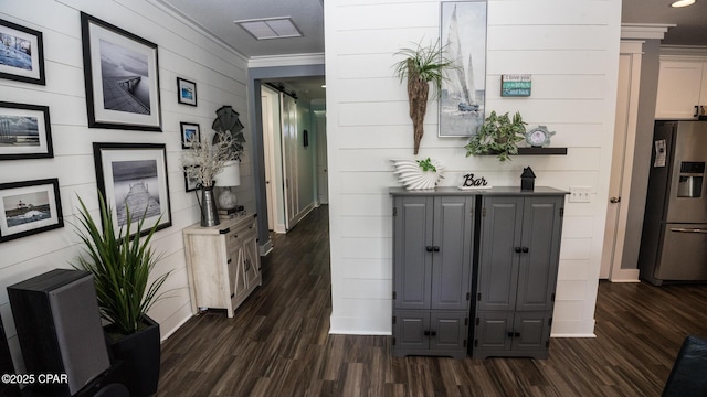 hallway featuring visible vents, baseboards, ornamental molding, and dark wood-style flooring