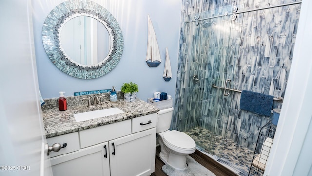 full bathroom with vanity, toilet, wood finished floors, and a stall shower