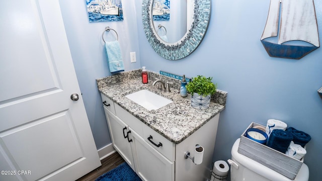 bathroom featuring vanity, toilet, and wood finished floors