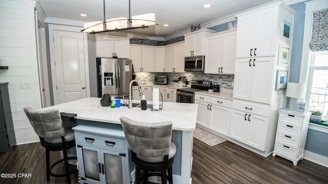 kitchen featuring decorative backsplash, white cabinets, dark wood-style floors, and stainless steel appliances