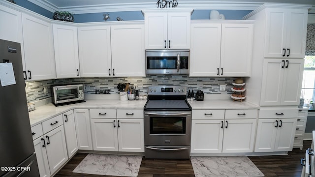 kitchen featuring a toaster, dark wood-style flooring, stainless steel appliances, white cabinetry, and tasteful backsplash