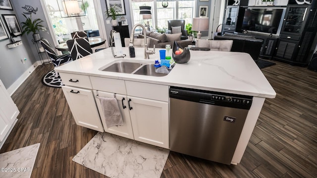 kitchen with dishwasher, a kitchen island with sink, open floor plan, and a sink