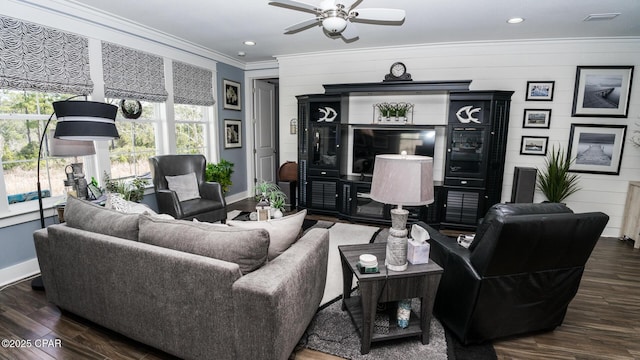 living room with wood finished floors, baseboards, and ornamental molding