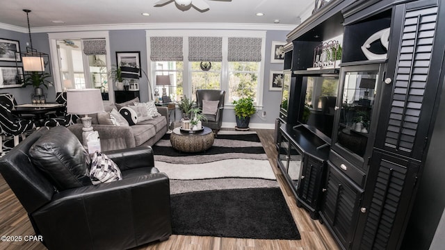 living area with a ceiling fan, wood finished floors, recessed lighting, crown molding, and baseboards