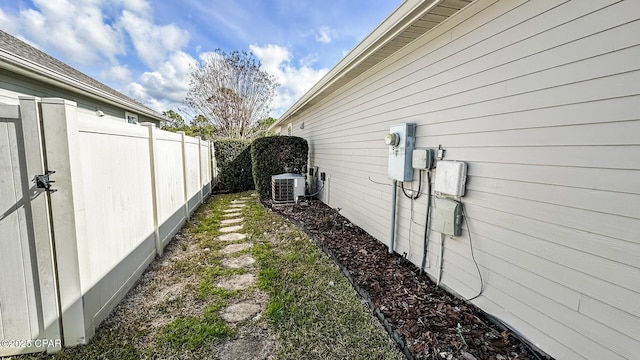 view of yard with central air condition unit and fence