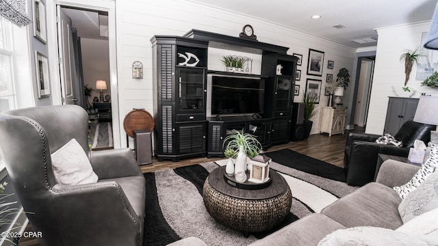 living room with ornamental molding and wood finished floors