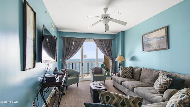 living area with carpet flooring, visible vents, and ceiling fan