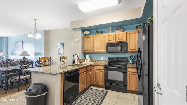 14825 Front Beach Rd Unit 2003, Panama City Beach, FL 32413 - kitchen featuring light tile patterned floors, light stone countertops, a peninsula, a sink, and black appliances