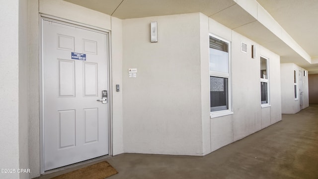 entrance to property featuring stucco siding