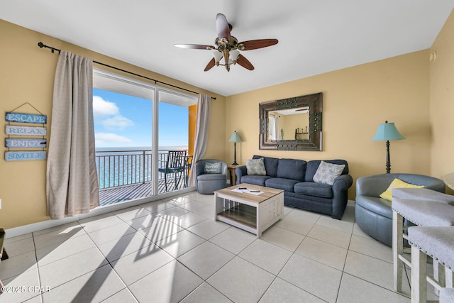 living area with ceiling fan, baseboards, and light tile patterned floors