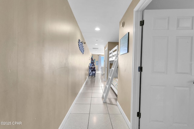 corridor featuring recessed lighting, baseboards, and light tile patterned floors