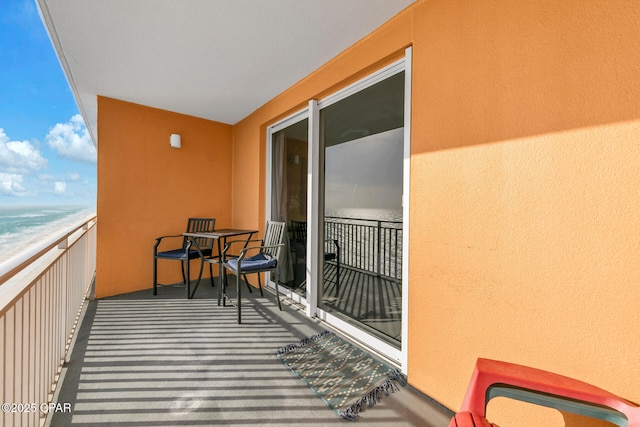 balcony featuring a water view and a beach view