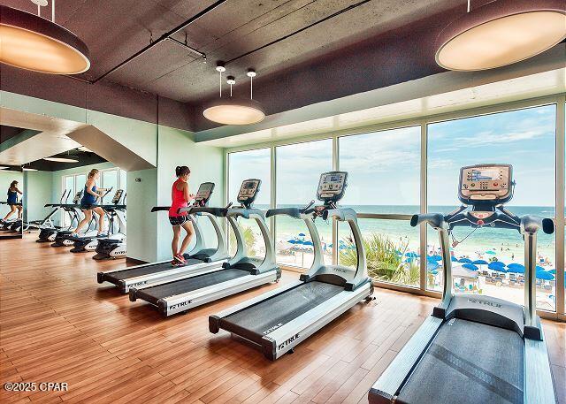 workout area with a wall of windows and wood finished floors