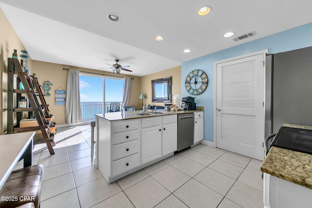 kitchen with light tile patterned floors, visible vents, dishwasher, a peninsula, and white cabinetry