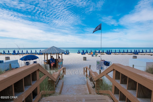 view of dock featuring a water view and a beach view