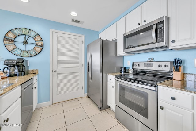 kitchen with visible vents, stainless steel appliances, light tile patterned floors, and white cabinetry