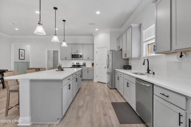 38 Cozy Cv, Freeport, FL 32439 - kitchen featuring a sink, a kitchen island, a kitchen breakfast bar, gray cabinetry, and stainless steel appliances