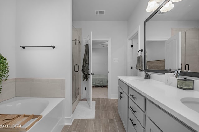 38 Cozy Cv, Freeport, FL 32439 - full bathroom featuring wood finish floors, a sink, visible vents, double vanity, and a bath