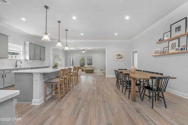 38 Cozy Cv, Freeport, FL 32439 - dining room featuring baseboards, ceiling fan, crown molding, and light wood finished floors