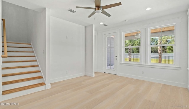 interior space featuring light wood-type flooring, visible vents, baseboards, and stairway