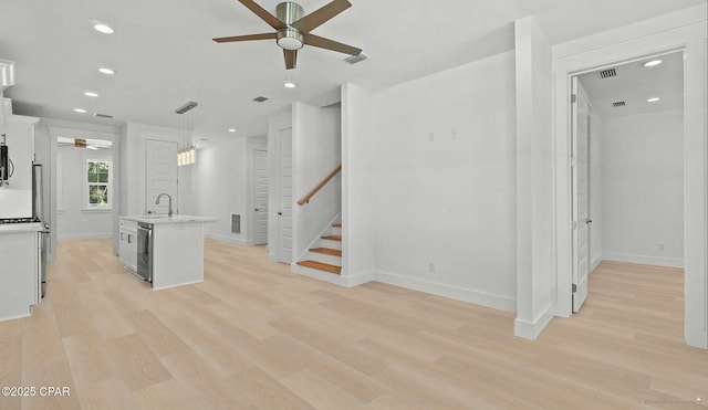 kitchen featuring a ceiling fan, visible vents, light countertops, light wood-style floors, and stainless steel dishwasher